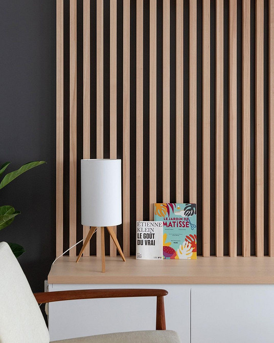 Minimalizm w Salonie Nowoczesny salon z minimalistyczną ścianką i dekoracjami na półkach.