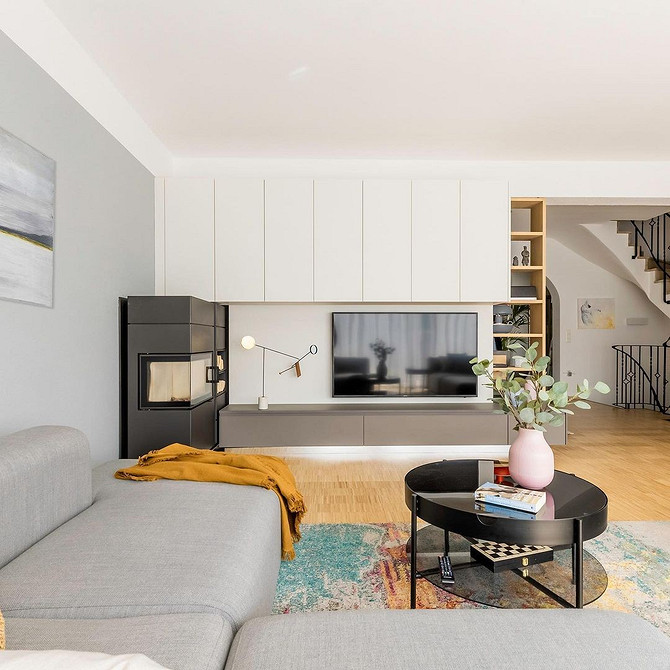 Drewniane Akcenty Nowoczesny salon z dużą ścianką meblową łączącą ciemne i jasne odcienie drewna.