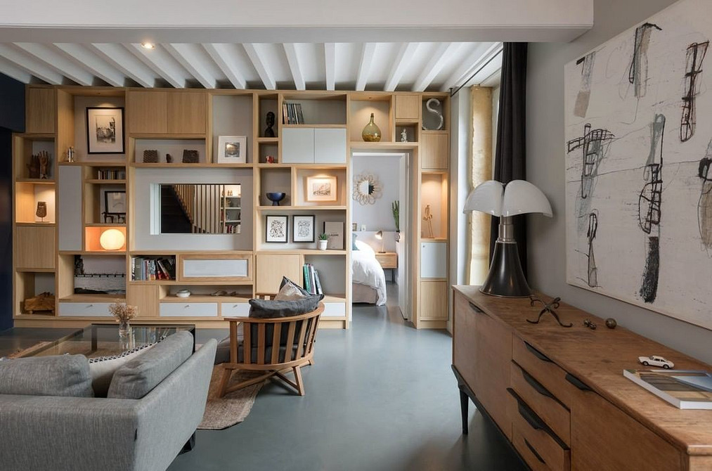 Kontrast w Salonie Stylowy salon z ciemną ścianką meblową kontrastującą ze ścianami.