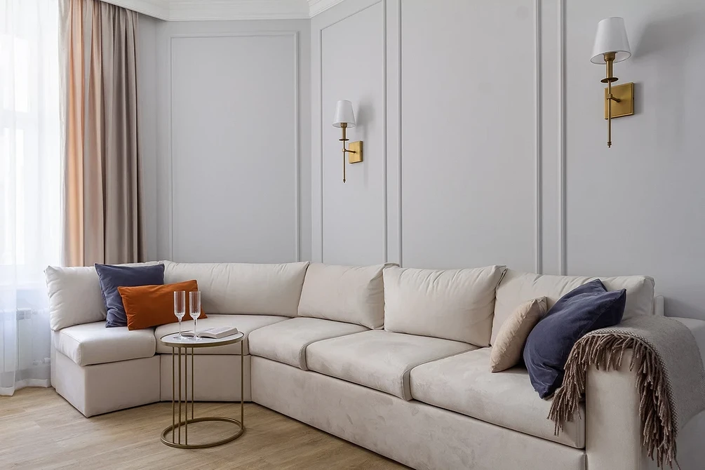 Biała sofa i drewno Stylowa biała sofa z drewnianymi akcentami i dywanem - aranżacje 2026