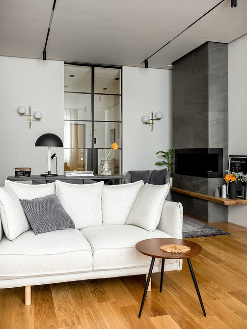 Drewniane nóżki sofy Stylowa biała sofa z drewnianymi nóżkami w jasnym salonie.