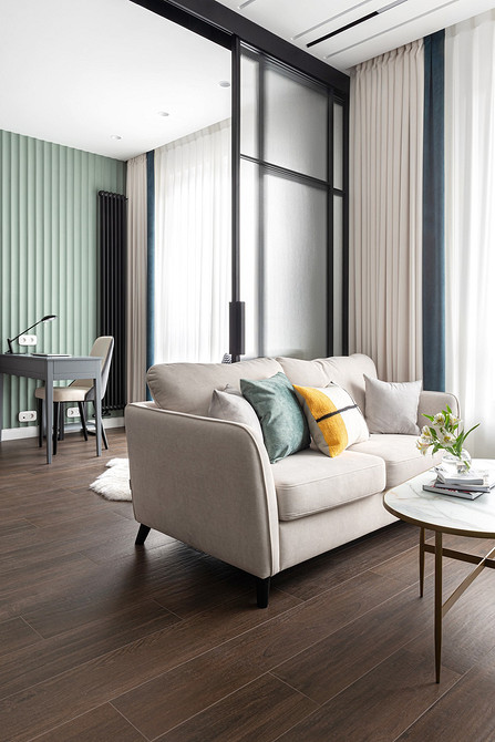 Biała sofa: tekstylny raj Biała sofa z tekstylną tapicerką, dużą ilością poduszek i pledem w salonie