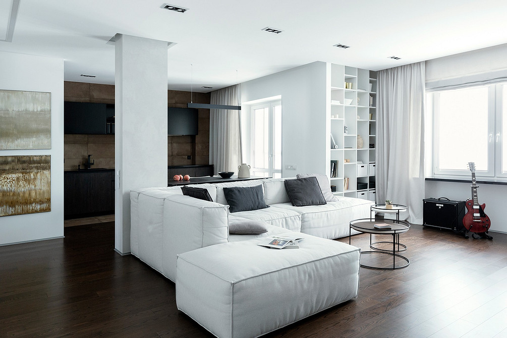 Komfortowa sofa w salonie Przytulna biała okrągła sofa w przestronnym salonie z dywanem, tworząca komfortową przestrzeń.