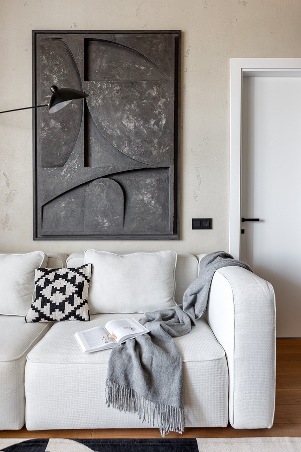 Skórzana sofa: Minimalizm Elegancka biała skórzana sofa w minimalistycznym wnętrzu z elementami drewna.