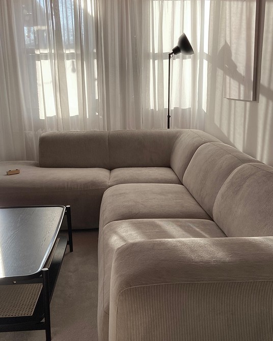 Sofa do małego mieszkania Beżowa sofa modułowa w małym mieszkaniu z drewnianym stolikiem kawowym