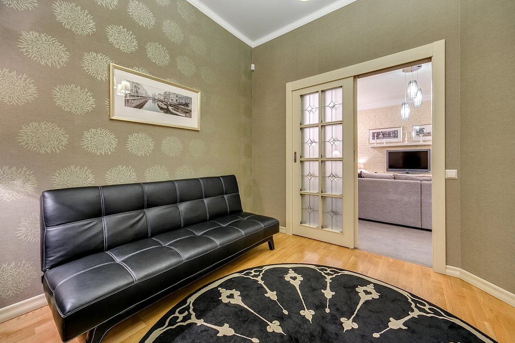 Stylowa, ciemna sofa minimalistyczna z drewnianymi nóżkami - idealna do salonu 2026.