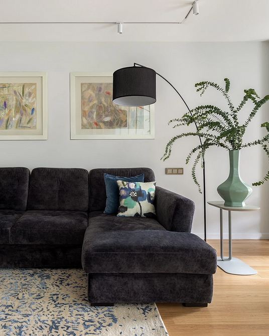 Skórzana sofa: klasyka Salon z ciemną skórzaną sofą i dopasowanym kolorystycznie dywanem. Inspiracja 2026.