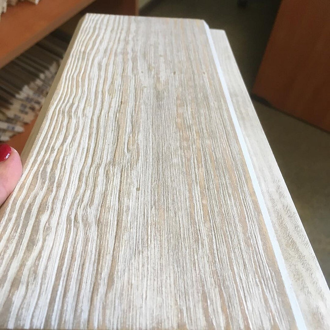 Postarzana deska drewniana z wyraźnymi pęknięciami i przetarciami, idealna do dekoracji ścian w stylu vintage.