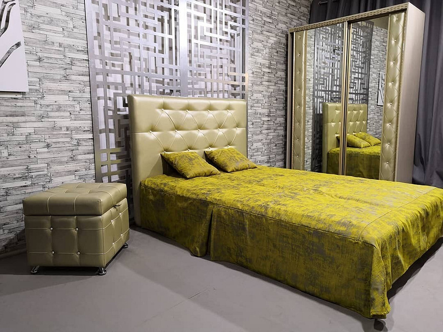 Minimalistyczny puf Mały, okrągły puf w minimalistycznym przedpokoju, praktyczny element wyposażenia.