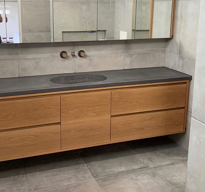 Harmonia w łazience Minimalistyczne meble łazienkowe i duże lustro tworzą harmonijną przestrzeń w łazience.