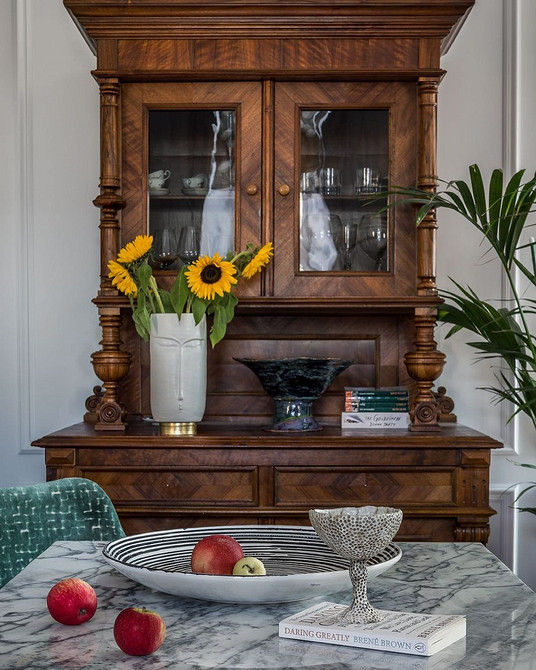 Serwantka przy kominku Serwantka z ciemnego drewna do salonu z kominkiem tworząca przytulną atmosferę 2026.