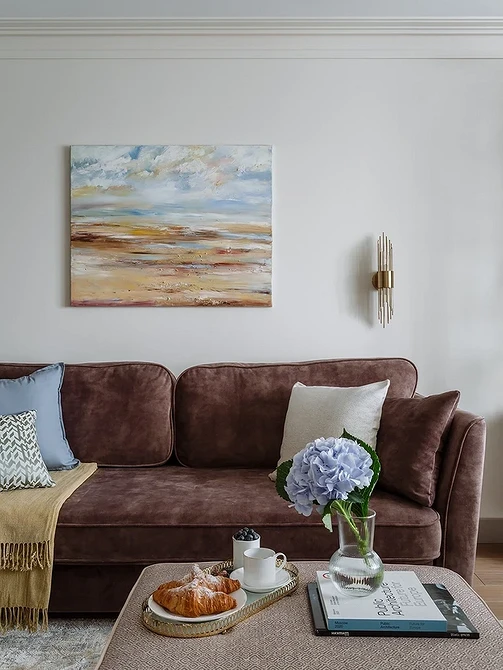 Narożny komfort Przytulna narożna brązowa kanapa w salonie z dywanem i stolikiem kawowym.