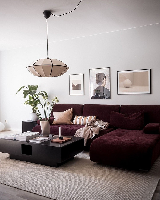 Nowoczesny salon z czerwoną sofą, poduszkami dekoracyjnymi i stolikiem kawowym. Aranżacja wnętrz 2026.