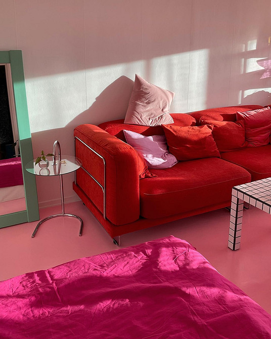 Mała sofa, duży efekt Sofa w odcieniach czerwieni w małym mieszkaniu. Funkcjonalne meble w salonie.