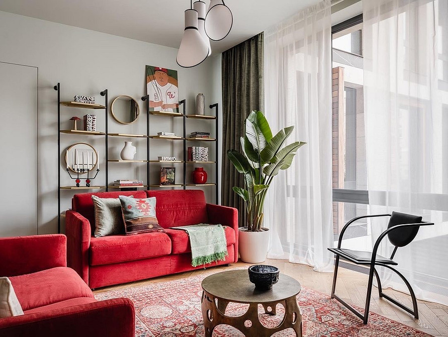 Minimalizm i czerwień Czerwona sofa w minimalistycznym salonie. Kontrastowe połączenie kolorów i stylów.