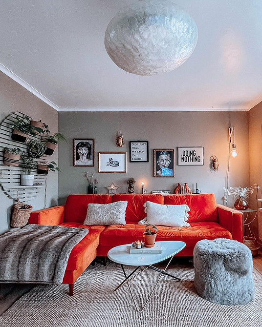 Połączenie kolorów w salonie: czerwona sofa i elementy dekoracyjne wnętrza 2026.