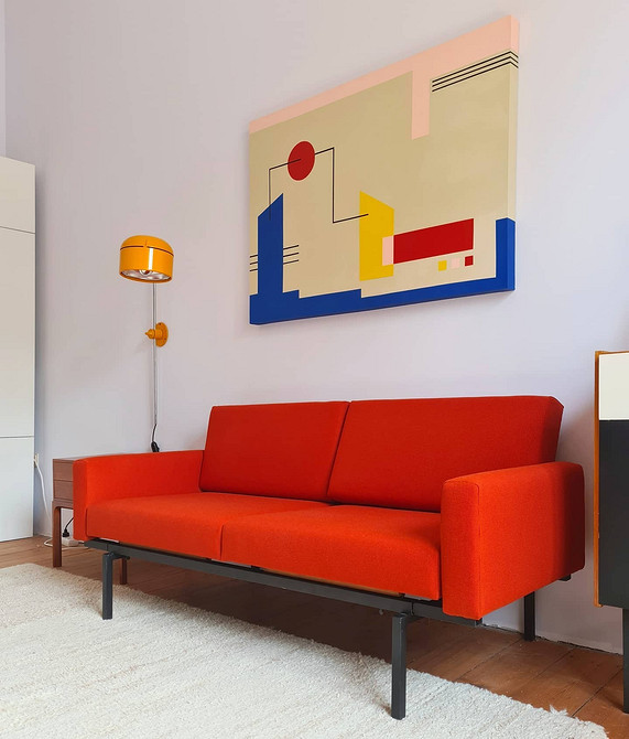 Nowoczesny salon z czerwoną sofą, poduszkami i wzorzystym dywanem - aranżacja 2026