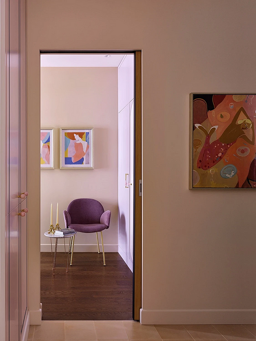 Przytulne krzesło w salonie Krzesło z drewnianymi podłokietnikami i miękką tapicerką w przytulnym salonie – aranżacja wnętrza.