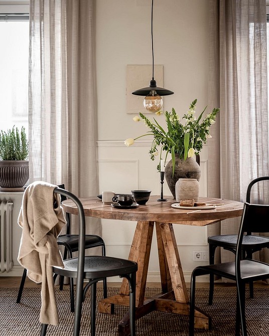 Rustykalny stół Przytulny okrągły stół w rustykalnej jadalni, ciepła atmosfera i drewno.