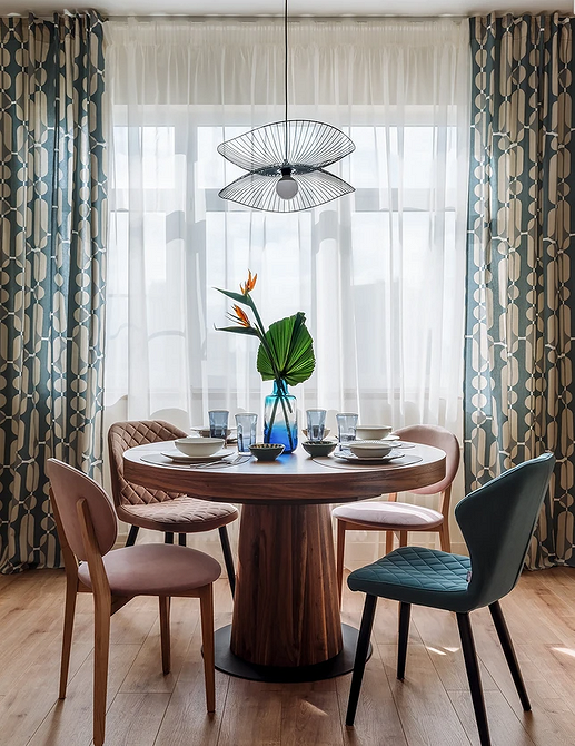 Designerski stół do jadalni Stylowy, okrągły stół w przestronnej jadalni z designerskimi krzesłami.