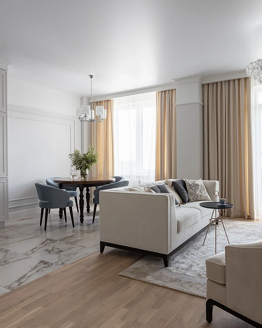 Nowoczesny stół okrągły Aranżacja salonu 2026: Okrągły stół z drewnianym blatem i nowoczesnymi krzesłami.