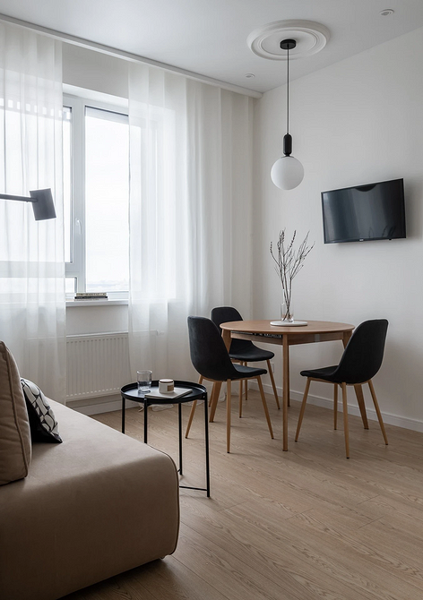 Okno: Stół z widokiem Stół przy oknie: Okrągły blat i widok na miasto, aranżacja z roślinami.