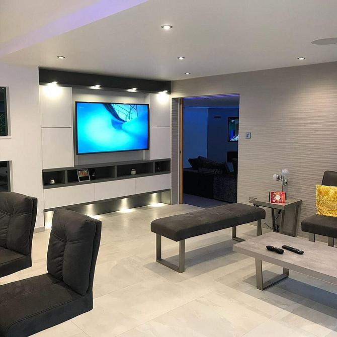 Kamień w kuchni Kuchnia z telewizorem w minimalistycznym stylu z elementami z naturalnego kamienia na ścianie.