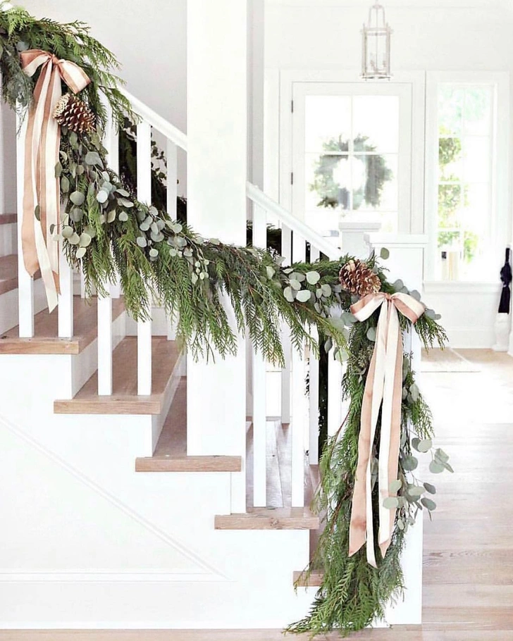 Świąteczna girlanda DIY Girlanda z gałązek igliwia zdobi drzwi wejściowe. Dekoracje DIY.