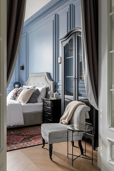 Szare łóżko i dodatki Stylowa sypialnia z dużym szarym łóżkiem, poduszkami i szafkami nocnymi.