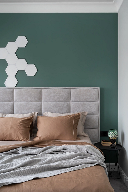 Szara i jasna Nowoczesna sypialnia z szarym łóżkiem, dużymi oknami i naturalnym światłem.