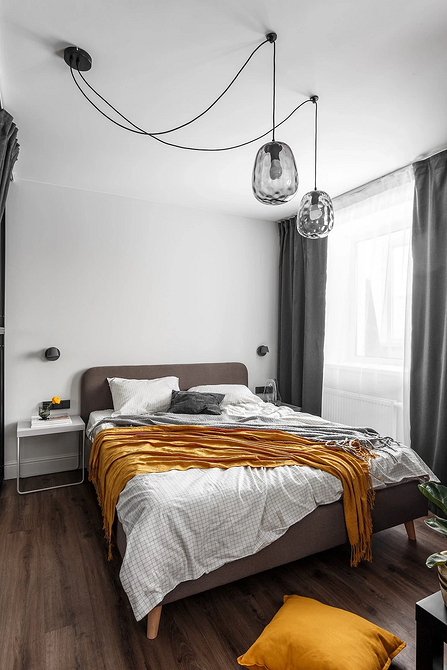 Sztuka w sypialni Sypialnia z szarym łóżkiem, ozdobiona obrazami i elementami dekoracyjnymi na ścianach.