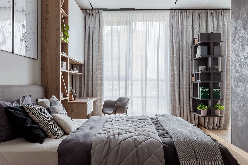 Szare łóżko, drewno, światło Stylowa sypialnia z szarym łóżkiem, drewnianą podłogą i nowoczesnymi lampami.