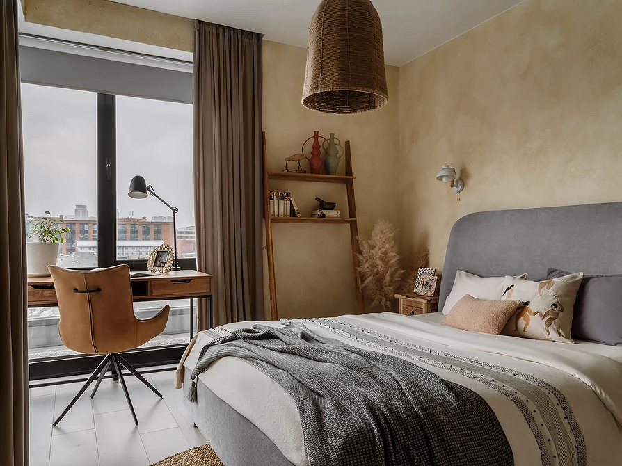 Szare łóżko, jasna pościel Wnętrze sypialni z szarym łóżkiem i pościelą w jasnych, neutralnych kolorach.