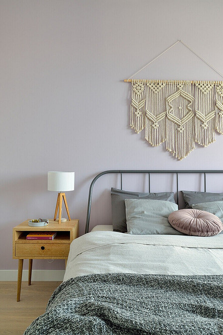 Szare łóżko nowoczesne Nowoczesne szare łóżko z wysokim zagłówkiem w przestronnej sypialni z dużymi oknami.