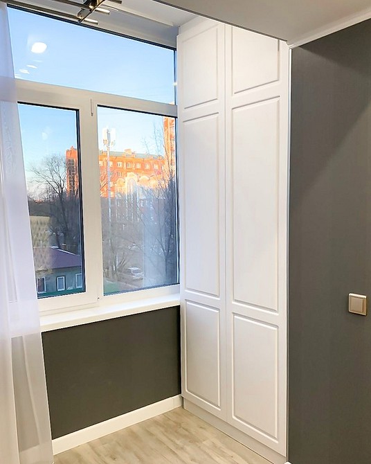 Harmonijna szafa Stylowy balkon z szafą do przechowywania, harmonijnie dopasowaną do aranżacji.