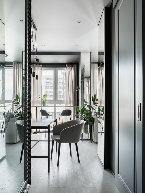 Minimalistyczne krzesło welurowe Wytworne krzesło z miękkim oparciem w jasnym, minimalistycznym wnętrzu salonu.