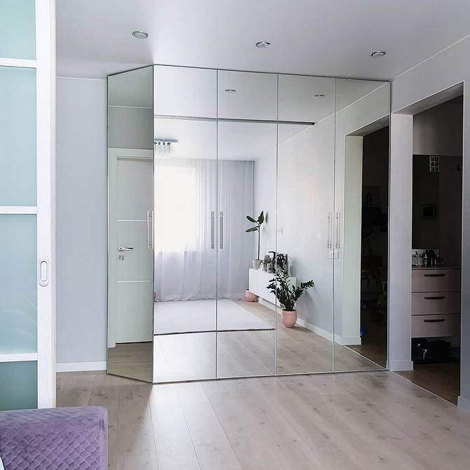 Świetlna Iluzja Jasny salon z szafą lustrzaną. Odbicie światła powiększa przestrzeń.